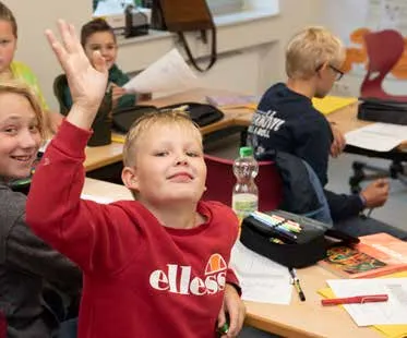 Ein Schüler meldet sich mit erhobener Hand