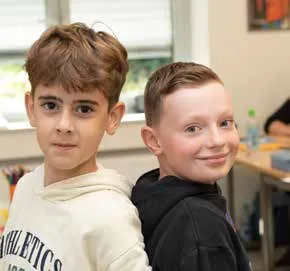 Zwei Schüler lächeln in die Kamera