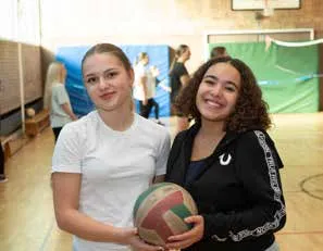 Zwei Schülerinnen mit einem Volleyball in der Turnhalle
