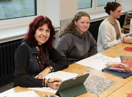 Eine Lehrerin sitzt mit Schülerinnen am Gruppentisch