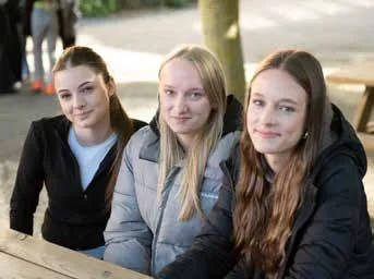 Drei Schülerinnen sitzen zusammen an einem Tisch